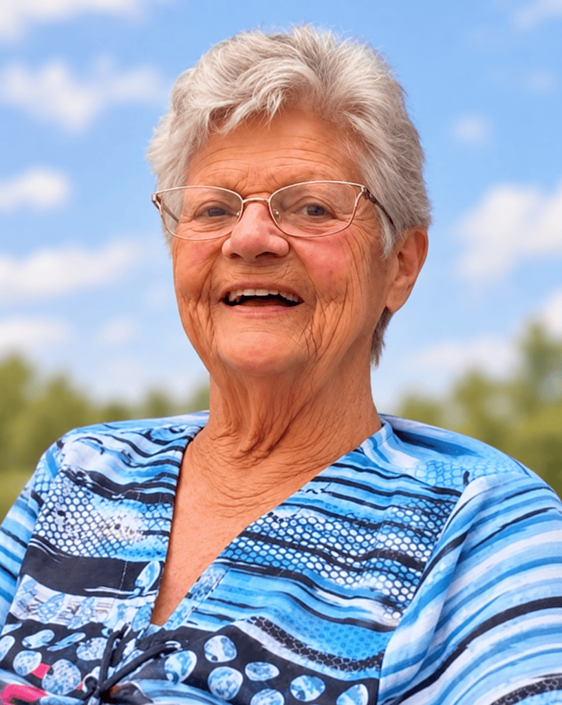 Sourire d'une femme âgée en plein air avec ciel bleu et arbres en arrière-plan.